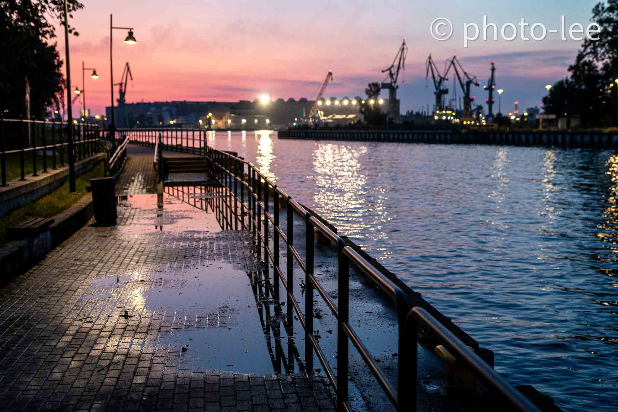 Der Himmel über dem Danziger Hafen leuchtet rot-orange über der blauen Reflexion des Wassers